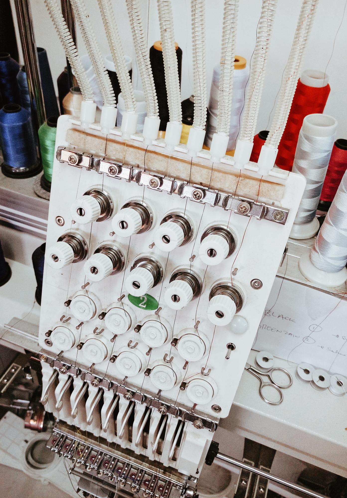 Studio workspace with embroidery machine and threads